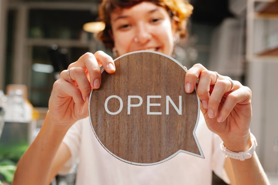 Woman holding open sign