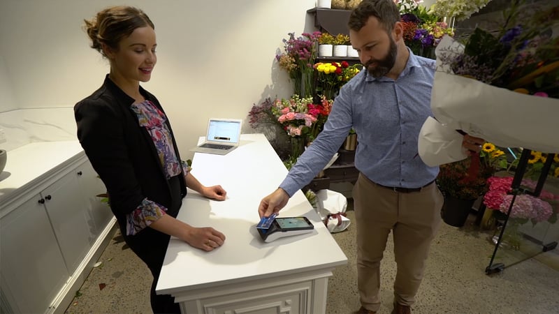 Business owner using an EFTPOS terminal at the counter of a New Zealand store